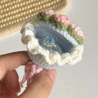 Handmade crochet ring box with flowers held by a hand