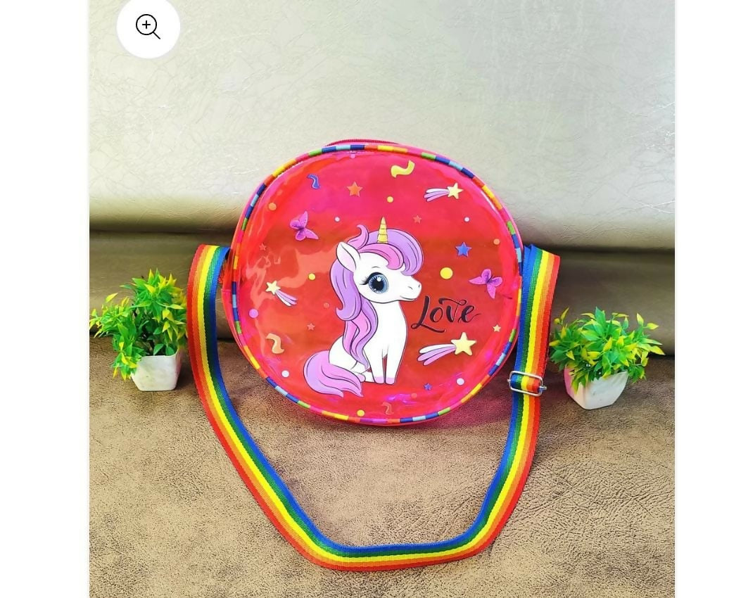 Children's crossbody bag with unicorn design on a beige surface with plants.