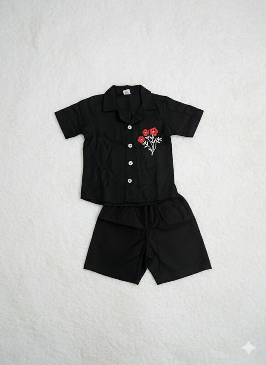 set of black short sleeved shirt and matching black shorts for a child.