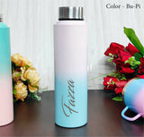 Gradient water bottle with 'Faizza' branding on a wooden surface with flowers.