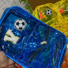 Blue transparent pouch with soccer ball design held by a hand, surrounded by other colorful pouches.