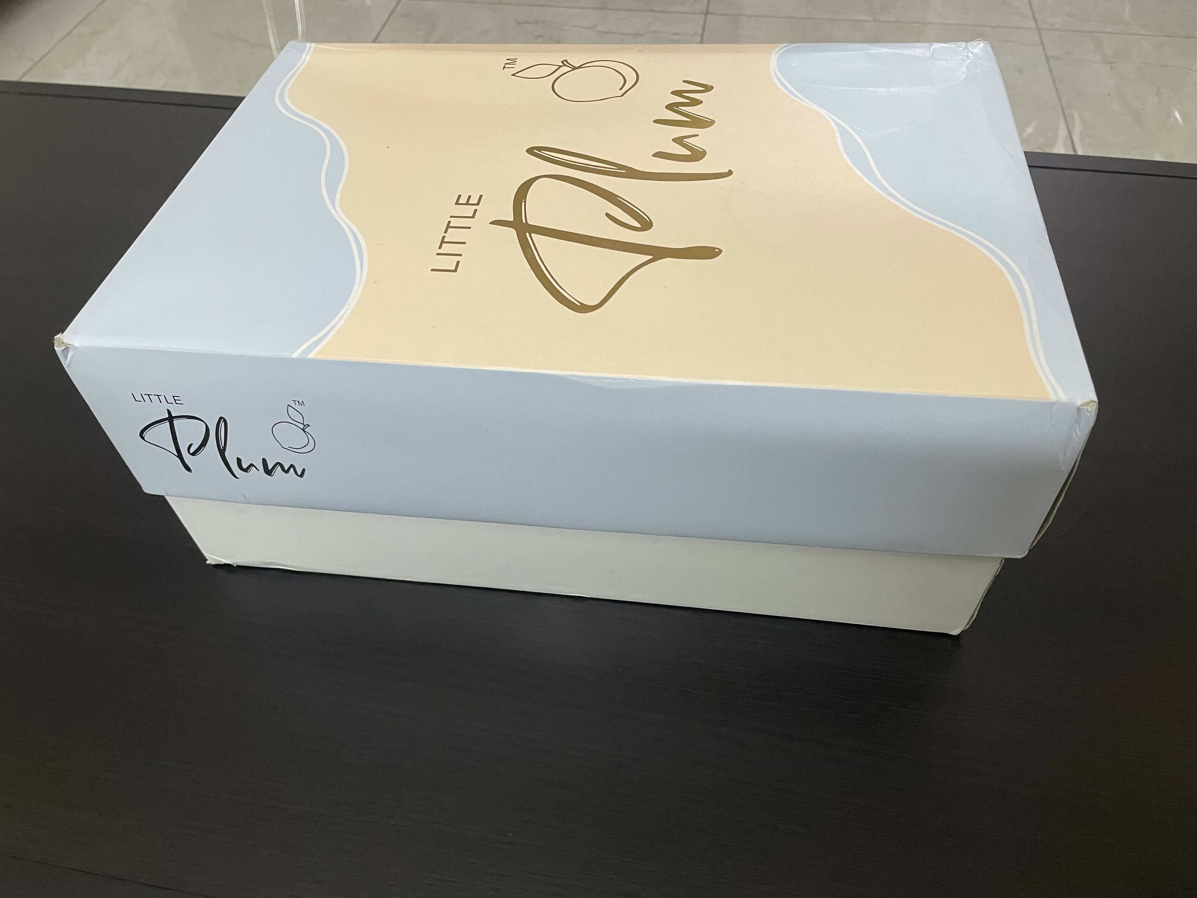 White box with 'Little Plum' branding on a dark surface