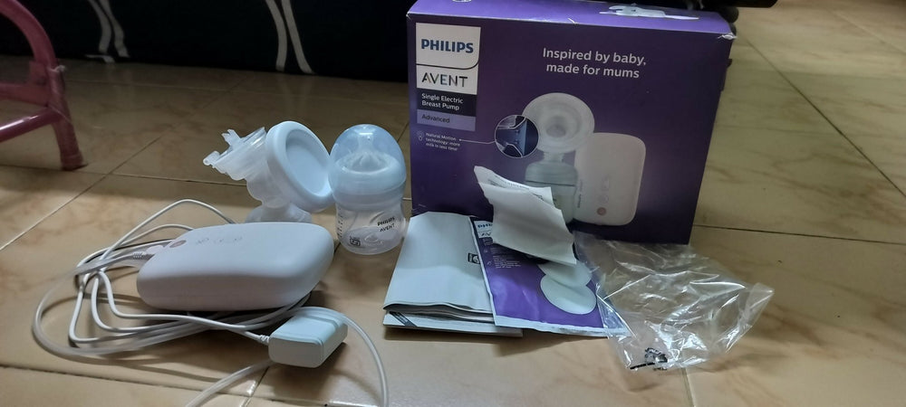 Philips Avent baby bottle and accessories on a wooden floor