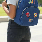 Person wearing a blue backpack with colorful patches and 'JAI' branding.