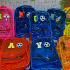 Colorful transparent backpacks with letters and sports ball designs on a white background