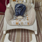 INFANTSO baby rocker and bouncer in beige for 0–2 years with cushioned seat, gentle rocking motion, secure harness, and comfortable design for baby relaxation and play.