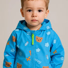 Child wearing a blue jacket with bear prints 