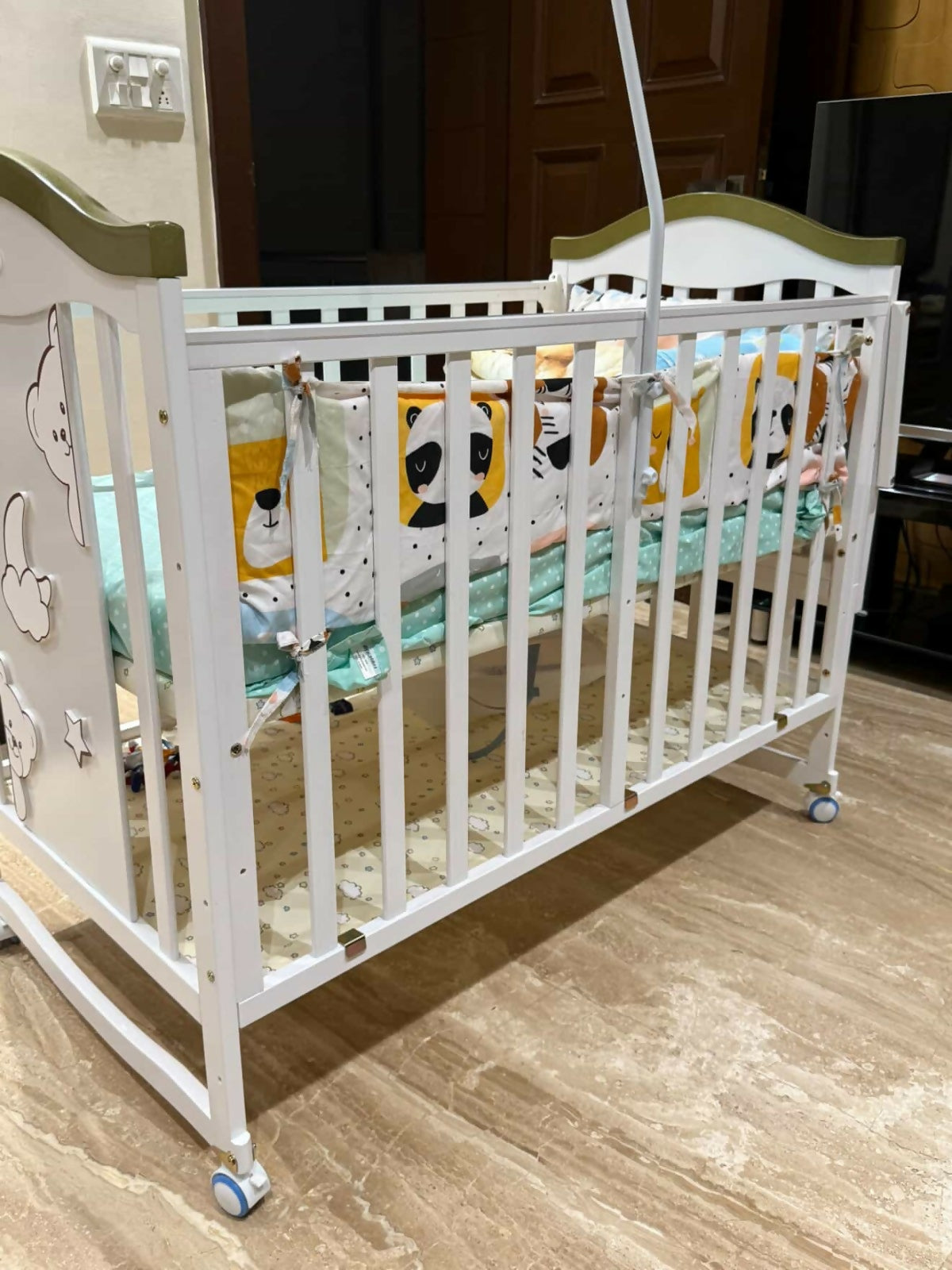 White crib with green accents in a room setting