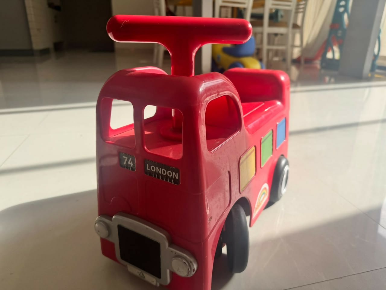 ELC Happyland Ride-On Bus with a colorful bus-inspired design, comfortable seat, sturdy wheels, easy-grip steering handle, and durable construction for fun indoor and outdoor riding play.