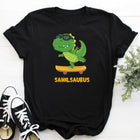Black t-shirt with a cartoon dinosaur on a skateboard and 'Sahilsaurus' text, paired with black and white sneakers.