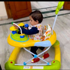 Child in a colorful walker on a tiled floor