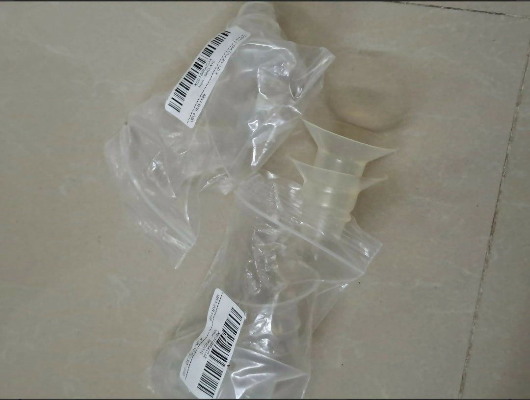 Clear plastic components with barcodes on a beige surface
