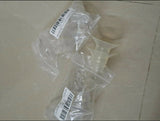 Clear plastic components with barcodes on a beige surface