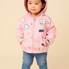 Child wearing a pink hoodie with cartoon designs 