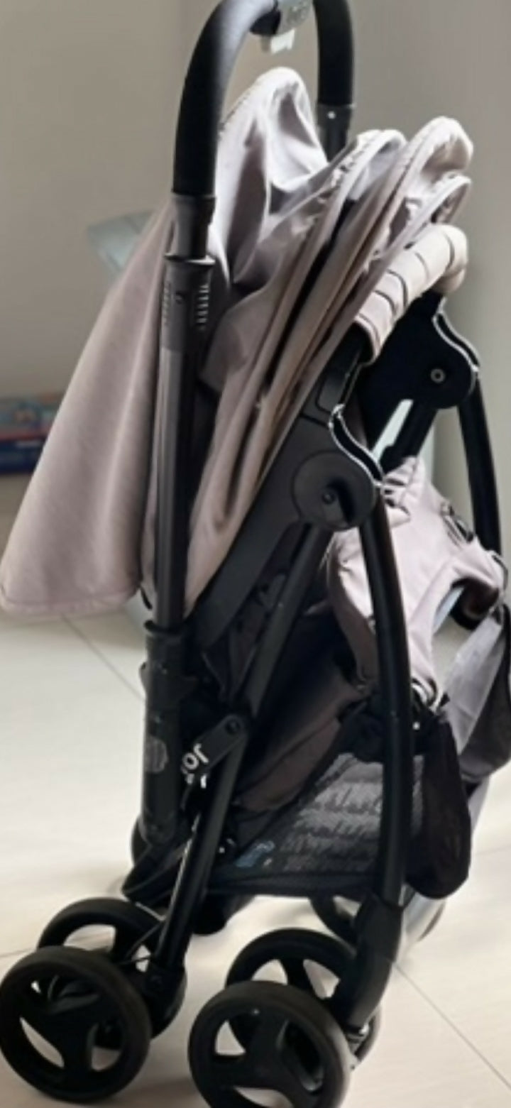 Folded baby stroller on a light-colored floor