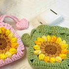 Two crocheted pouches, one pink and one green, with a sunflower pattern 
