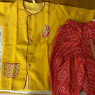 Yellow garment with floral patterns and red fabric on a yellow background