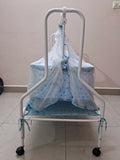 Baby crib with blue canopy and mattress on a white background