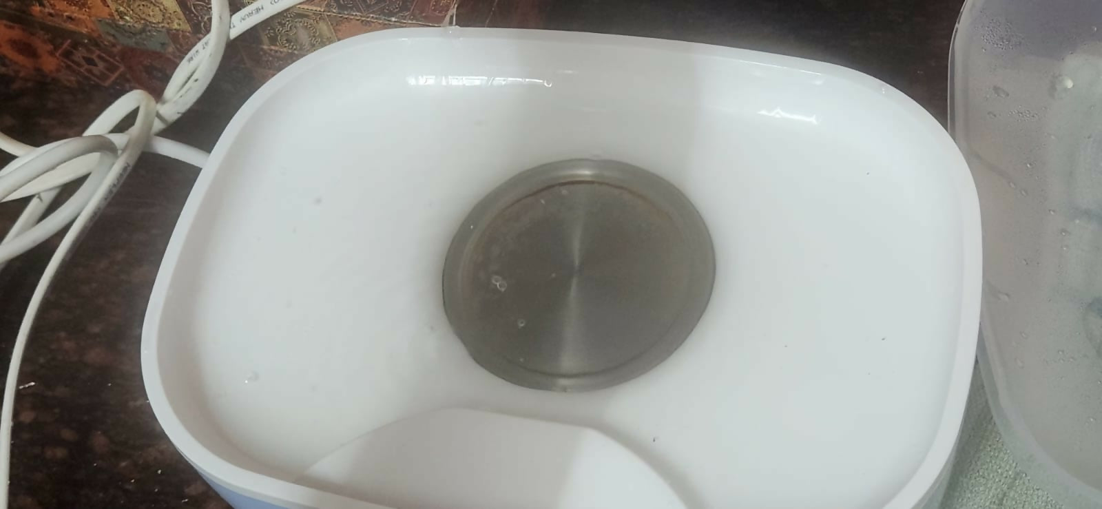 White appliance with a silver component on a countertop