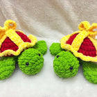 Two green turtles with red hearts and yellow crowns on a white background