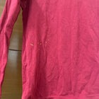 Pink long-sleeve shirt on a wooden surface