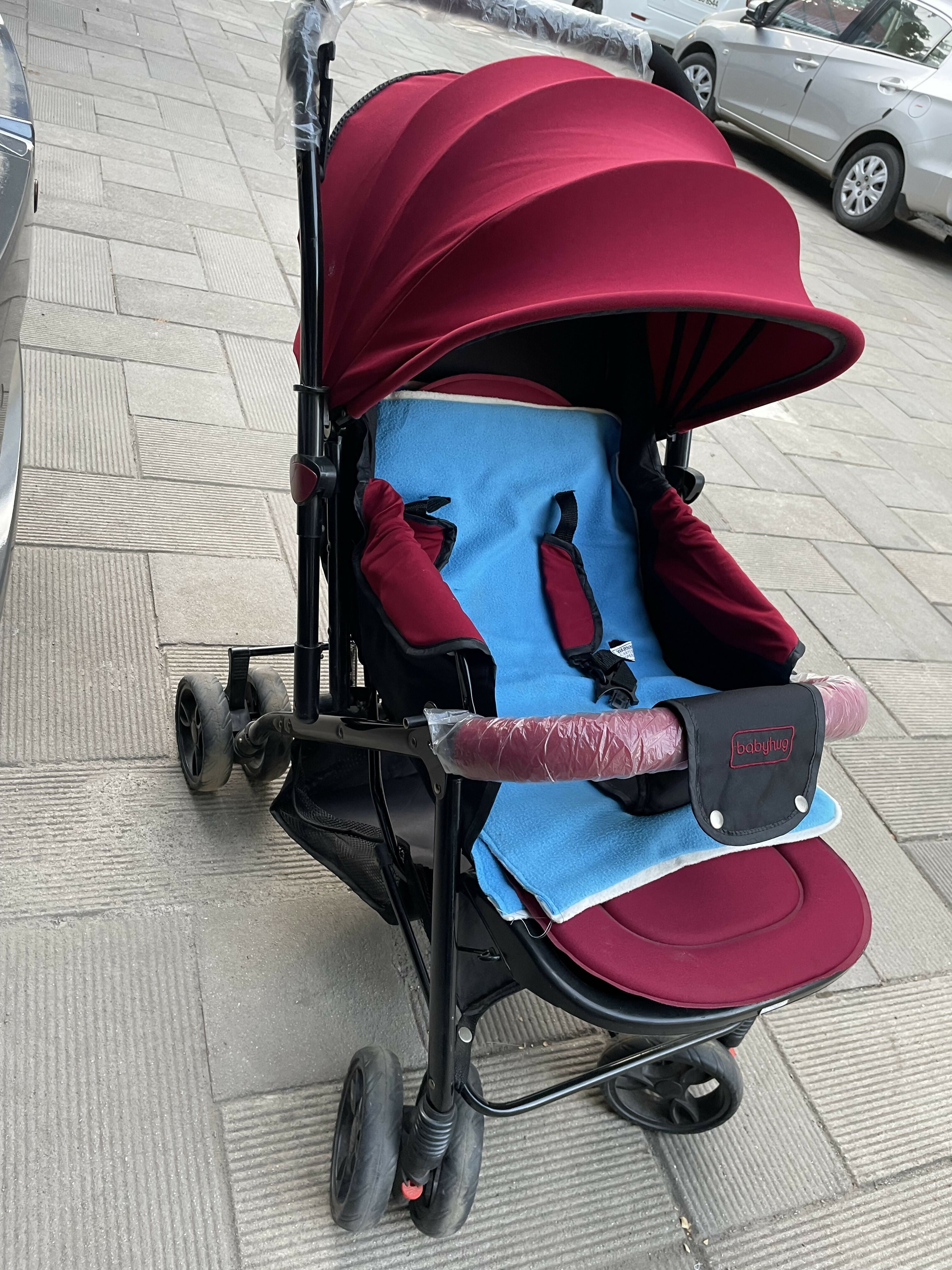 Nearly new red baby stroller with sun canopy, padded seat, lightweight design, and foldable convenience—ideal for on-the-go families!