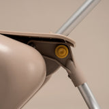 Close-up of a beige mop with a yellow wheel on a beige background