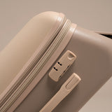 Close-up of a beige suitcase with a zipper and handle on a neutral background
