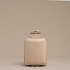 Beige suitcase with a handle on a beige background