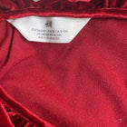 Red velvet garment with H&M label on a neutral background