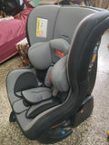 Gray and black car seat with visible branding on a concrete floor.