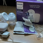 Philips Avent breast pump set on a wooden floor with packaging.