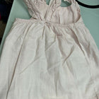 Light-colored dress with straps on a light green surface