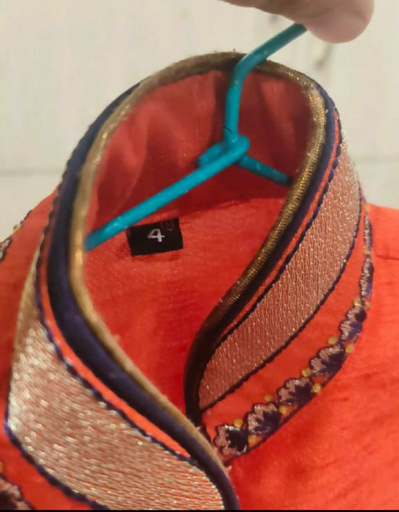 Close-up of a red hat with decorative elements and a blue ribbon on a blurred background