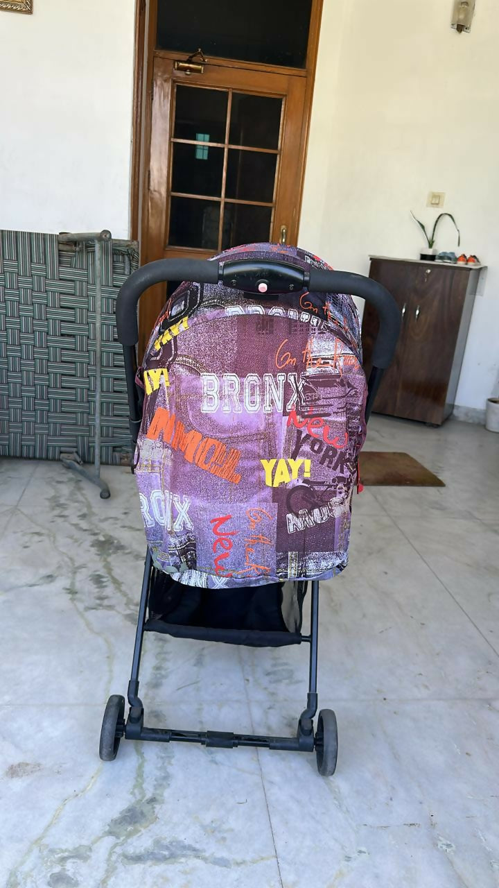 Stroller with a colorful cover on a tiled floor