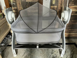 MEE MEE Swing Cradle for Baby featuring a mosquito net, comfortable mattress pad, gentle swinging design and wheels with locking function for convenient movement and supervised resting at home.