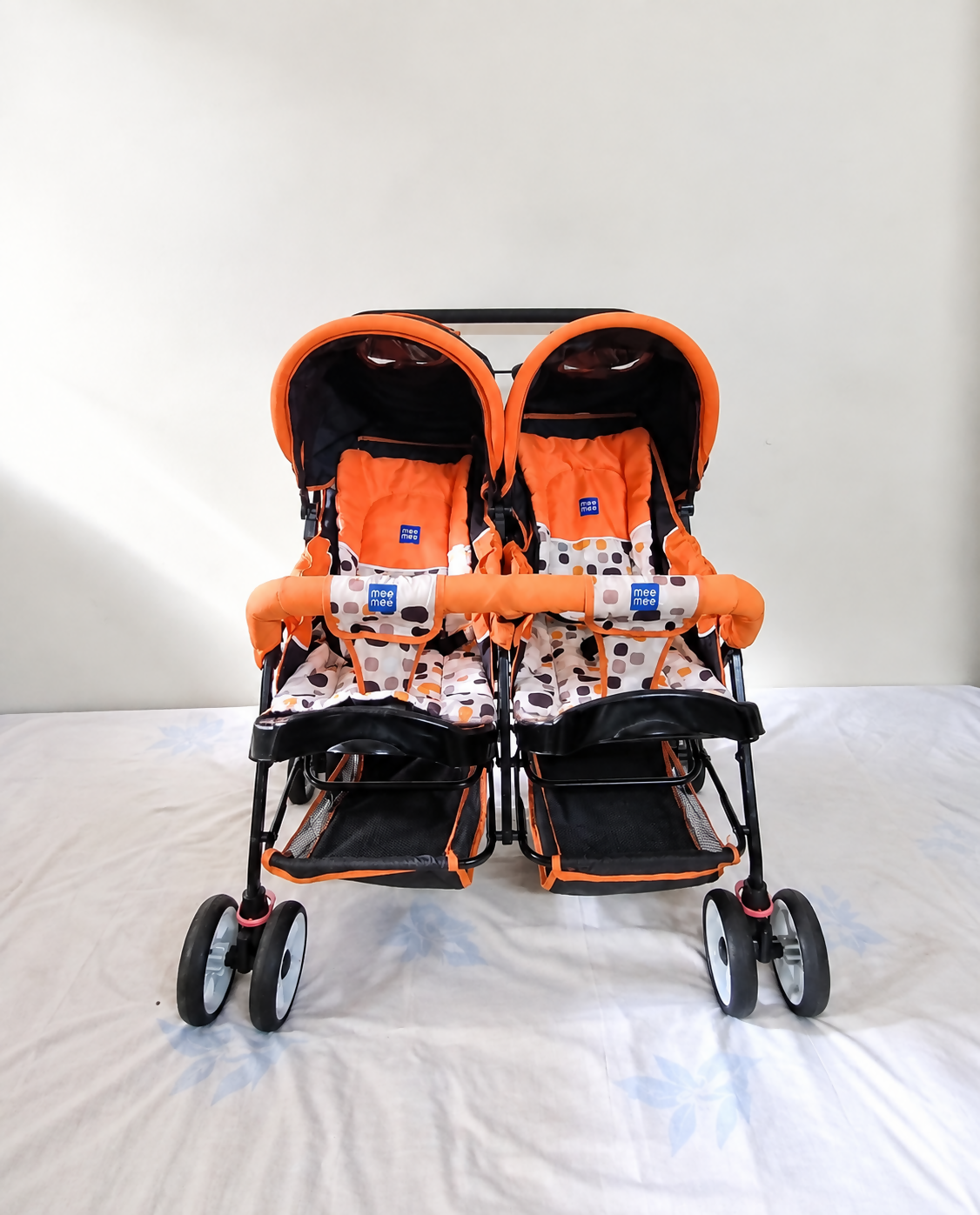 MEE MEE Twin Baby Stroller/Double Pram in Orange, Some Used condition, featuring two seats, reclining design, protective canopies and a foldable frame for convenient outings with twins or two young children.