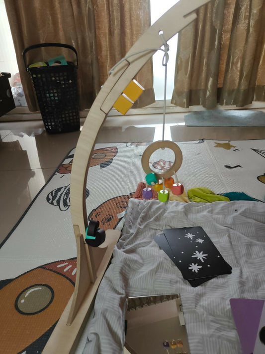 Baby playpen with toys and cards on a colorful mat