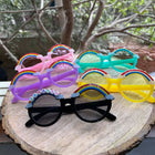 Colorful sunglasses with decorative elements on a wooden surface