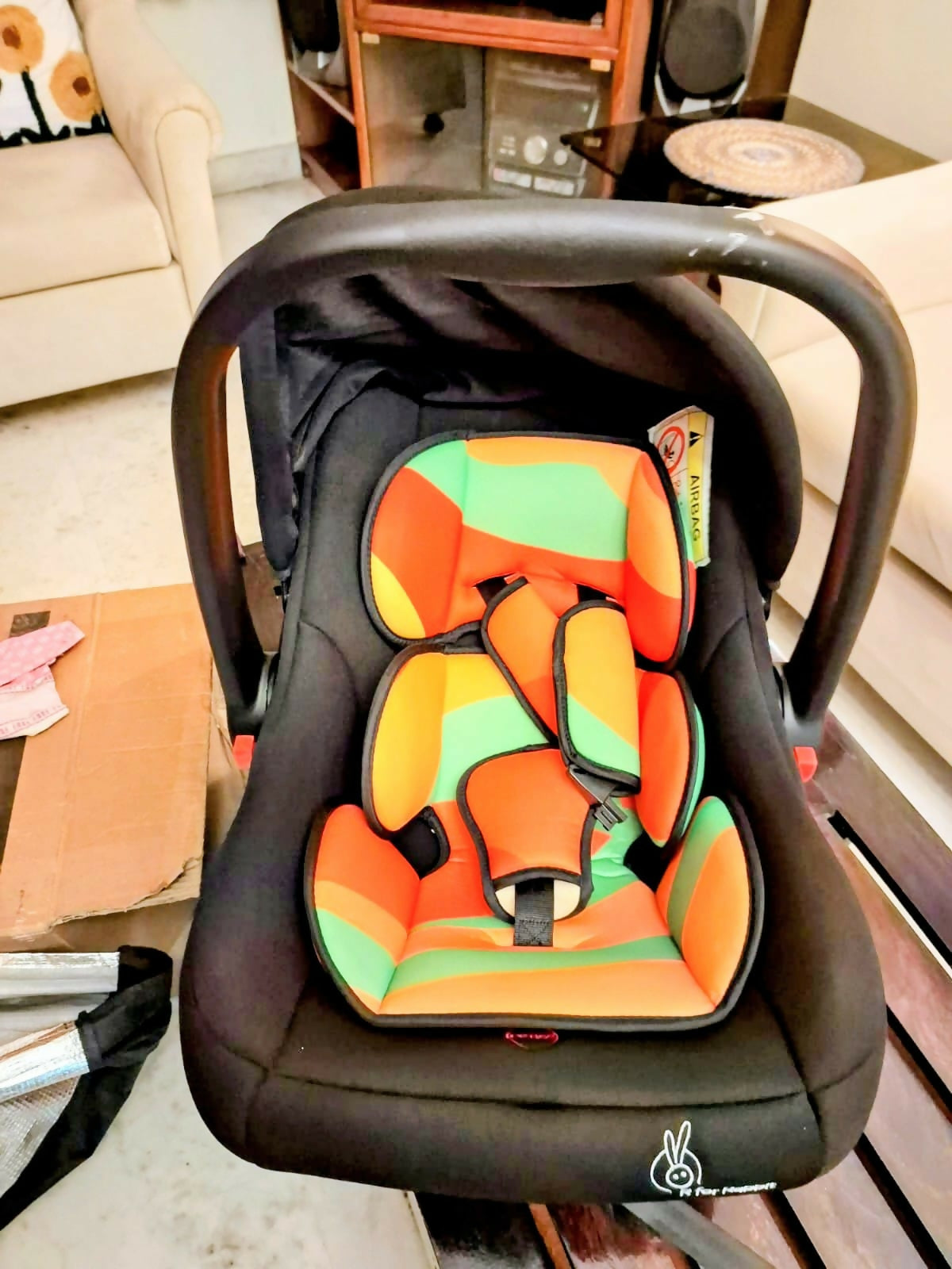 R for Rabbit Picaboo infant car seat with rear-facing design, cushioned seating, secure safety harness, ergonomic carry handle, and protective side support for safe and comfortable travel with newborns and infants.