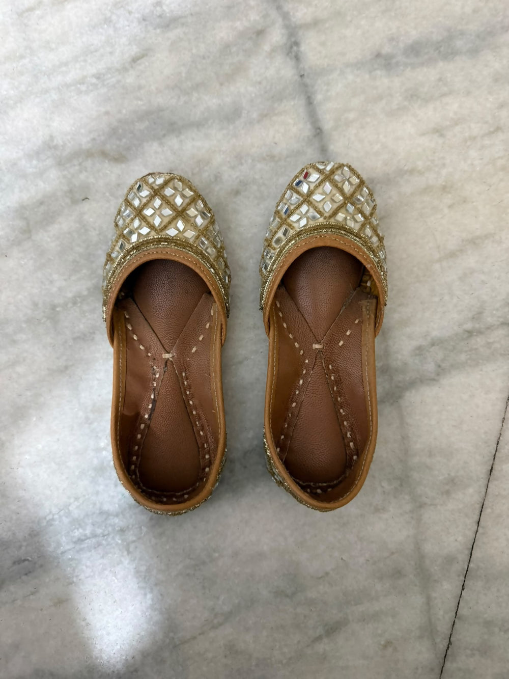 Golden Punjabi Jutti with decorative mirror work detailing for festive and traditional outfits.