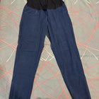 Blue pants with a black waistband on a patterned surface