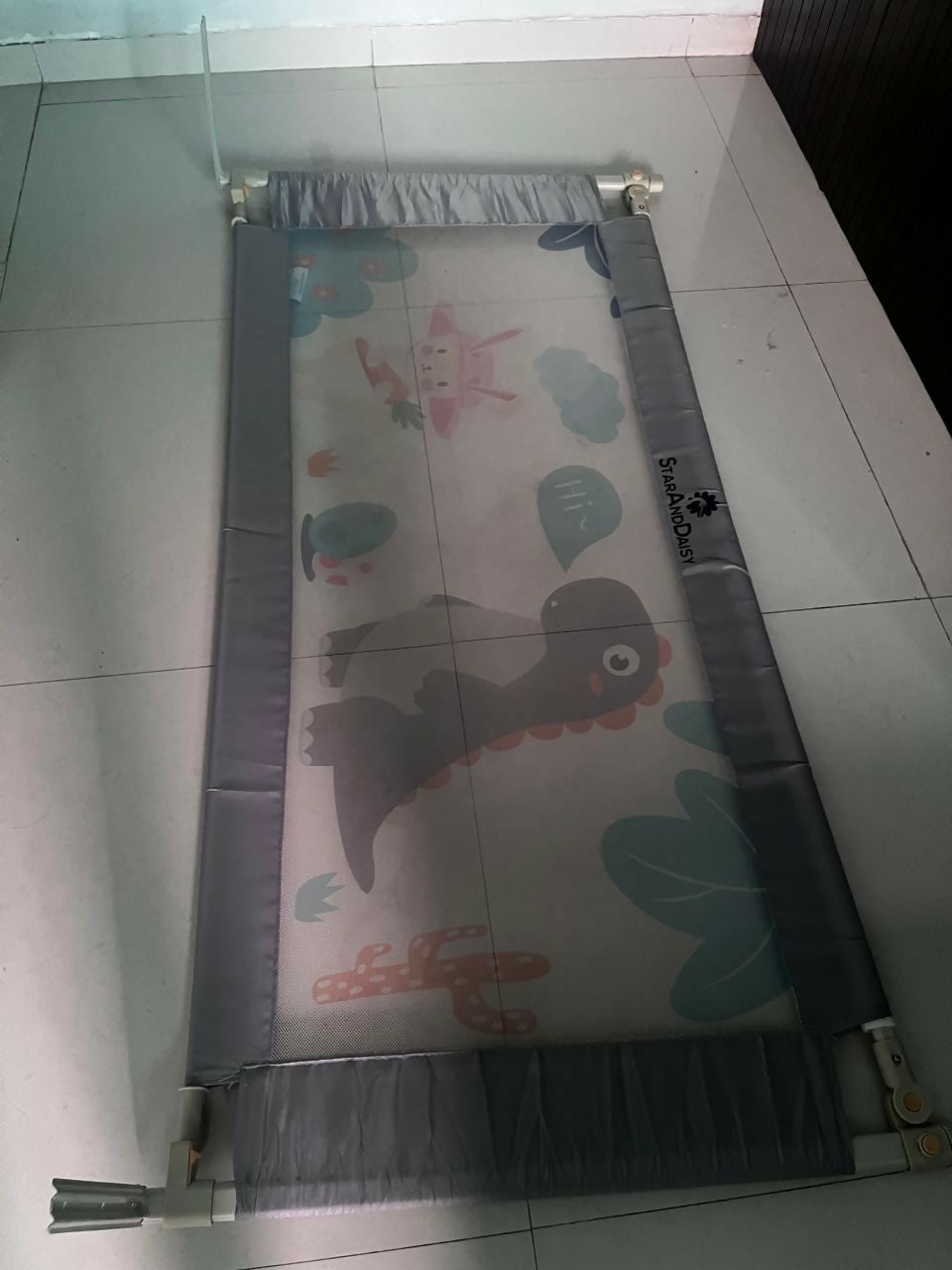 Children's play mat with dinosaur design on a tiled floor