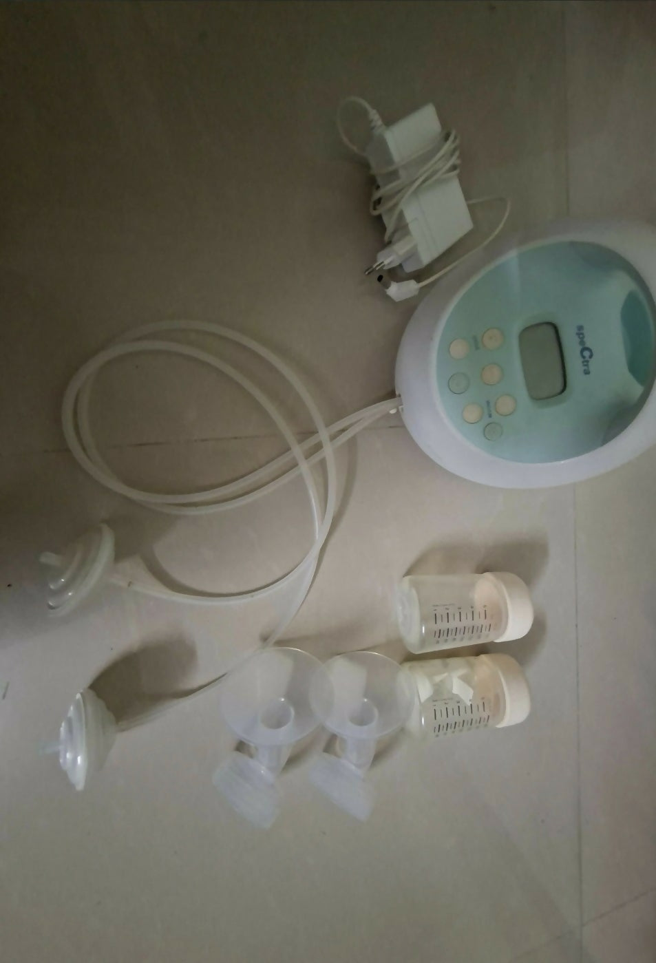 Breast pump set with bottles and accessories on a light surface