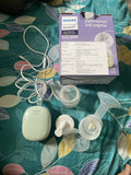 Philips Avent breast pump parts on a patterned fabric background