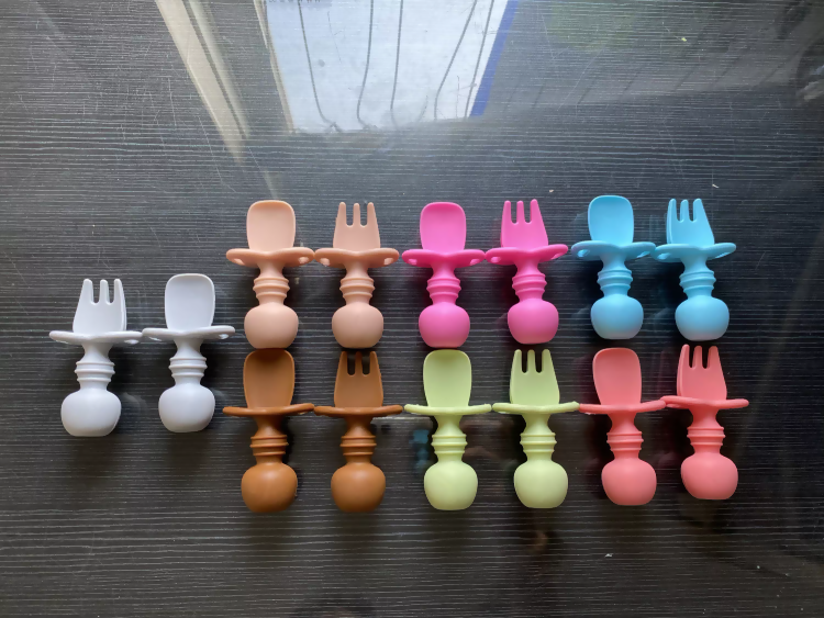 Silicone spoon and fork set made from food-grade BPA-free silicone with soft rounded edges, ergonomic handles, and a gentle design for safe self-feeding by babies and toddlers.