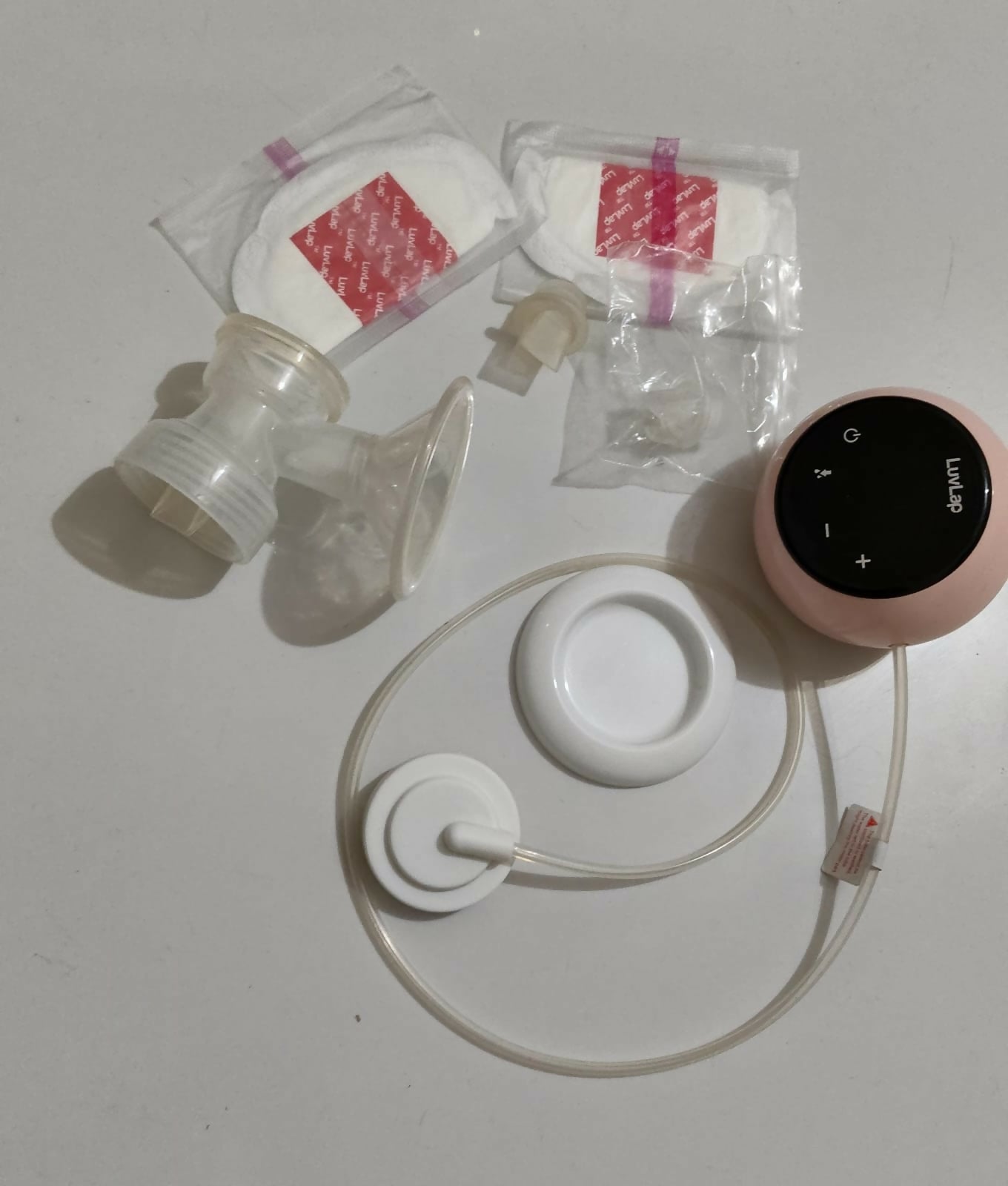 LUVLAP Adore single electric breast pump with adjustable suction settings, compact design, milk collection bottle, and comfortable pumping support for breastfeeding mothers.