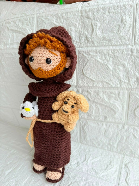 Handmade St. Francis of Assisi crochet doll crafted from soft yarn with detailed stitching, a gentle expression, and a charming design for gifting, collecting, or nursery décor.