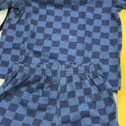 Blue checkered outfit with shirt and shorts on a yellow background