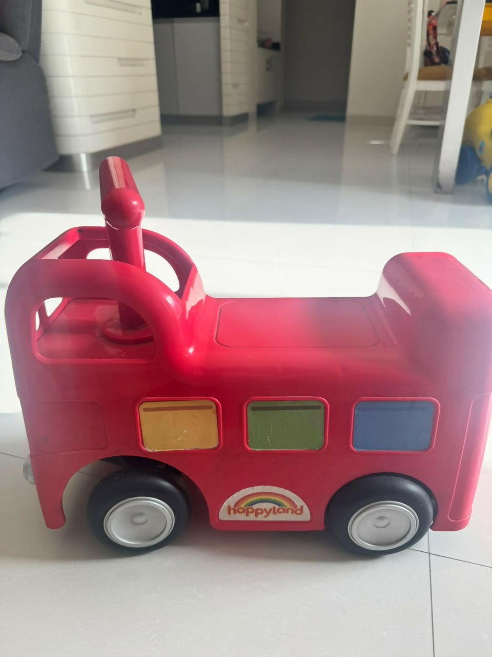 ELC Happyland Ride-On Bus with a colorful bus-inspired design, comfortable seat, sturdy wheels, easy-grip steering handle, and durable construction for fun indoor and outdoor riding play.